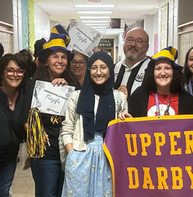  Teachers congratulate Nazifa Arna in the hallway with banners and pom poms!